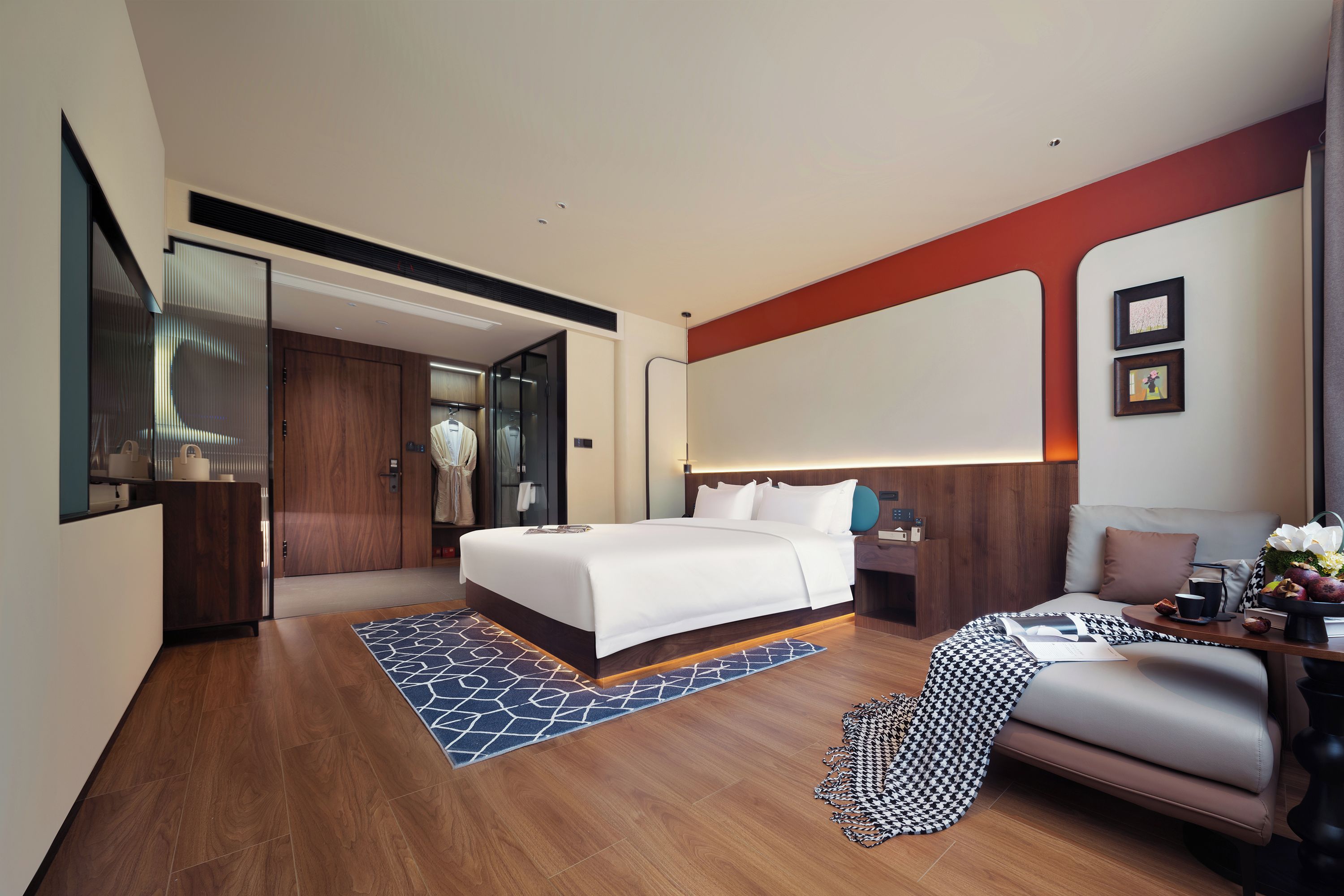 A modern hotel room with a large bed, a seating area, and a bathroom.