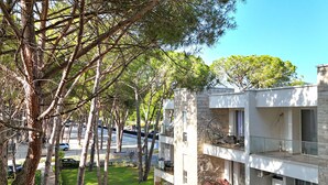 Un bâtiment moderne doté de nombreux balcons, d’un espace extérieur aménagé pour s’asseoir et d’une pelouse bien entretenue.