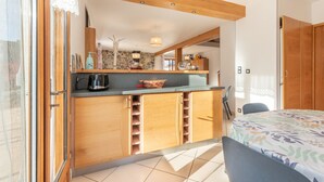 Una cocina moderna con armarios de madera, cafetera y un salpicadero de piedra.
