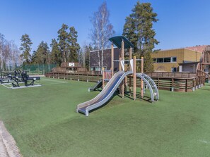 Ein Spielplatz mit Rutsche, Klettergerüsten und Sportgeräten.