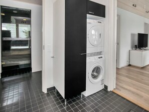 A modern laundry room with a black door, a washing machine, and a dryer.