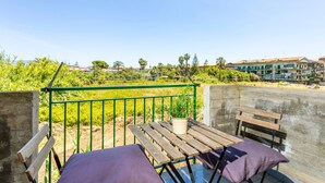 Ein Balkon mit einem Holztisch, einer Bank und einem Topfpflanze.