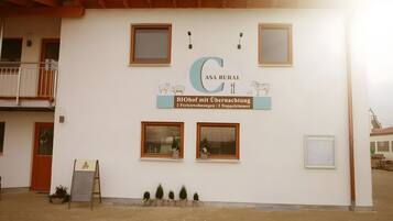 Un bâtiment portant une enseigne indiquant : « ASA RURAL BIOhof mit Übernachtung 2 Ferienwohnungen 2 Doppelzimmer. »