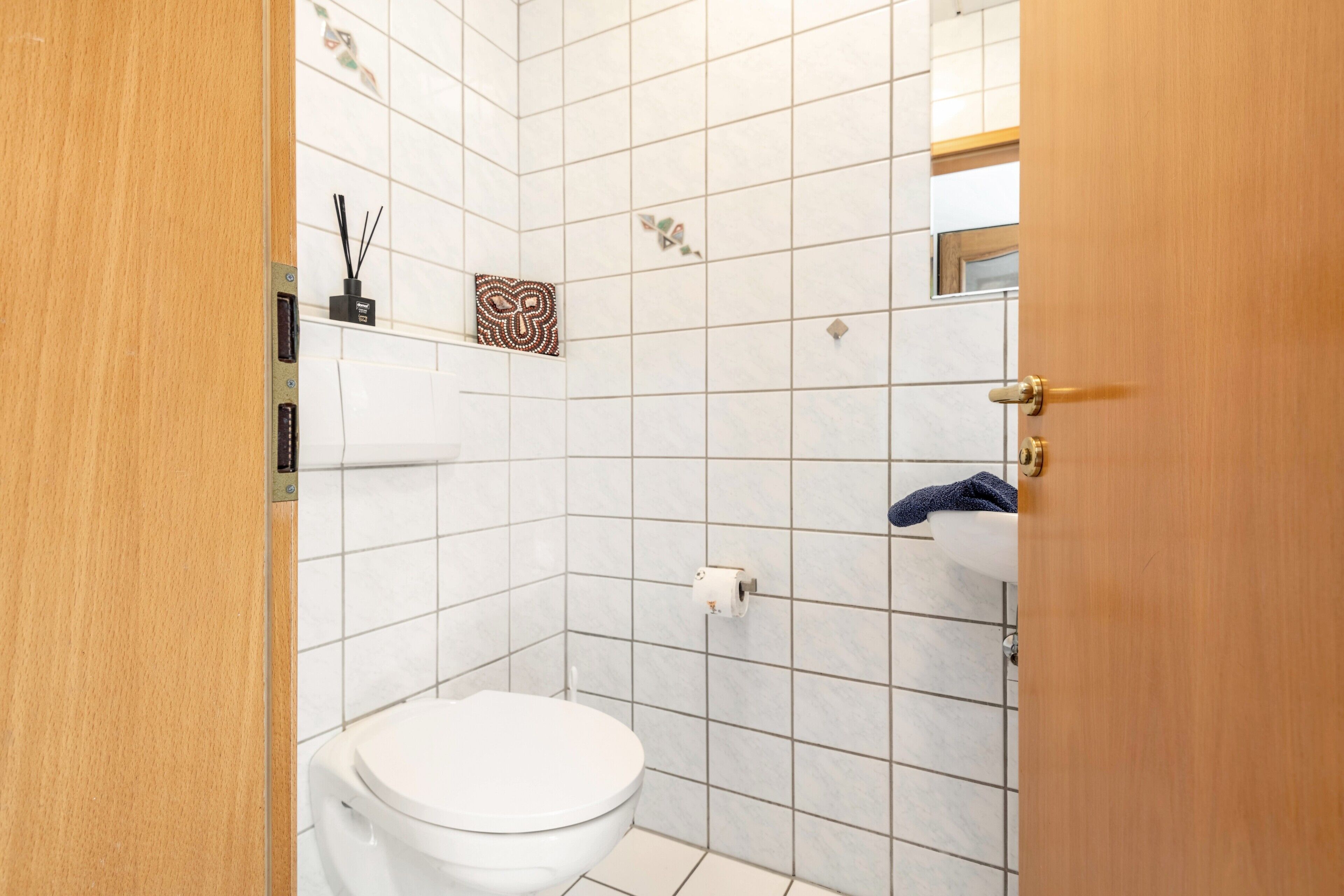 A bathroom with a toilet, a sink, and a shower area.