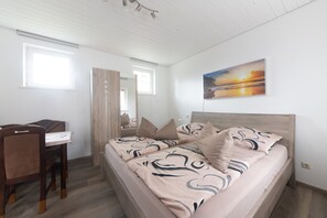 Une chambre à coucher avec un lit, un bureau, une chaise et une fenêtre.