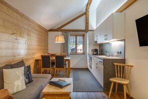 A compact living space with a wooden interior, a dining area, and a kitchenette.