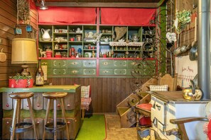 Une cuisine chaleureuse avec des meubles en bois, un plan de travail rouge et divers ustensiles de cuisine.