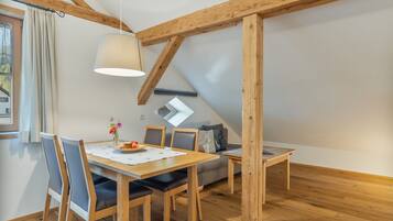 Un comedor con una mesa de madera, sillas y una lámpara colgante.