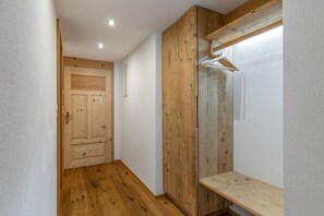 Un couloir doté d’un plancher en bois, d’une porte en bois et d’une armoire en bois avec un miroir.