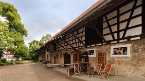 A traditional half-timbered building with a cobblestone street, wooden benches, and barrels outside. - Apartment 'Stallblick' with Shared Terrace, Shared Garden and Wi-Fi (Bad Urach)