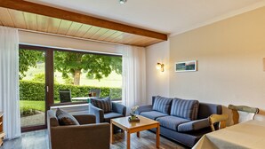 A modern living room with a sofa, armchair, and a table. - Apartment (Fuchsbau, 30 sqm) with Private Terrace and Wi-Fi (Schmallenberg)
