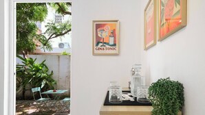 Una habitación con un armario de madera, una mesa con cristalería y una planta colgante.