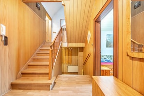 Un intérieur en bois avec un escalier menant à une pièce comprenant un lit et une fenêtre.