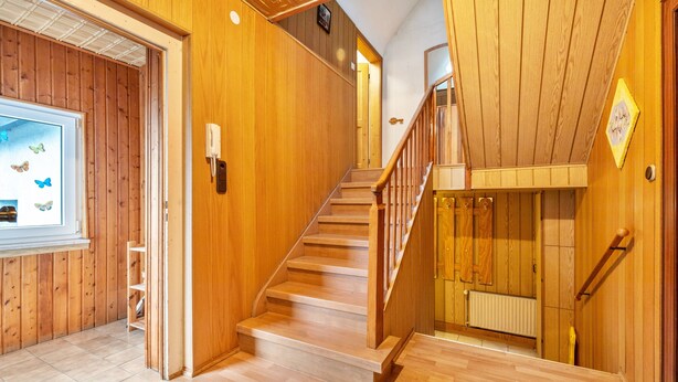 A wooden staircase with a handrail, a wooden wall, and a window with a butterfly decal. - Apartment 'Messe Hannover' with Shared Terrace, Shared Garden and Wi-Fi (Hannover)