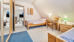A bedroom with a bed, desk, chair, and a mirror on the wall. - Apartment 'Messe Hannover' with Shared Terrace, Shared Garden and Wi-Fi (Hannover)