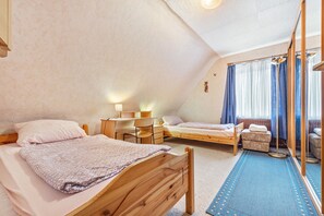A bedroom with two wooden beds, a desk, a chair, and a small seating area. - Apartment 'Messe Hannover' with Shared Terrace, Shared Garden and Wi-Fi (Hannover)