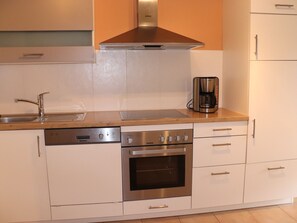 Een koelkast, een oven, een kookplaat, een vaatwasser