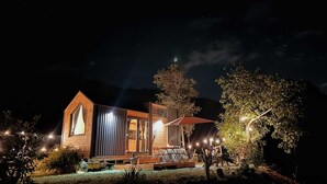 A wooden cabin with a large window, a deck, and a tree in the foreground. - La Casa Errante 3 by Tiny Away (Castilenti)
