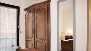Un dormitorio con una cama doble, un armario y un espejo.