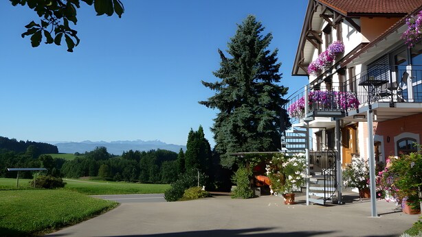 A building with balconies, a clear sky, and a view of mountains. - Apartment Obstgarten, 55 sqm, 2 bedrooms, max. 4 persons (Lindau)