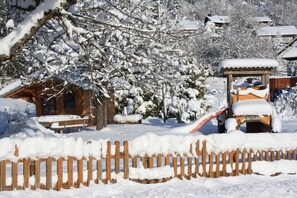 A wooden cabin with a snow-covered roof, surrounded by snow-laden trees and a wooden fence. - Apartment 'Eichentraum' with Mountain View, Shared Garden and Wi-Fi (Ibach)