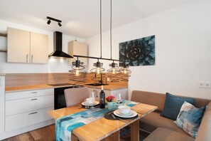 Eine moderne Küche mit Essbereich, einer Couch und einem Gemälde an der Wand.