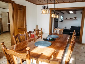 Una sala da pranzo con un tavolo in legno, sedie e un lampadario.