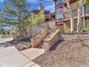 A stone staircase leading to a building with a stone facade and a small balcony.