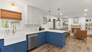 A modern kitchen with blue cabinets, white countertops, and stainless steel appliances. - The Salty Tortoise - By Beach (Jekyll Island)