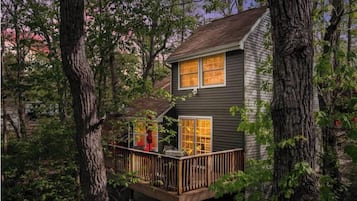 Una casa con terraza, rodeada de árboles.