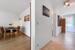Ein Essbereich mit einem Holztisch und Stühlen, einer Blumenvase und einem Bild an der Wand.