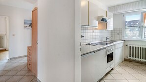 A kitchen with white cabinets, a stove, and a window. - Apartment '3' with Private Garden, Balcony and Wi-Fi (Hagnau am Bodensee)