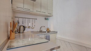 Una cocina con armarios de colores claros, electrodomésticos de acero inoxidable y un salpicadero de mármol.