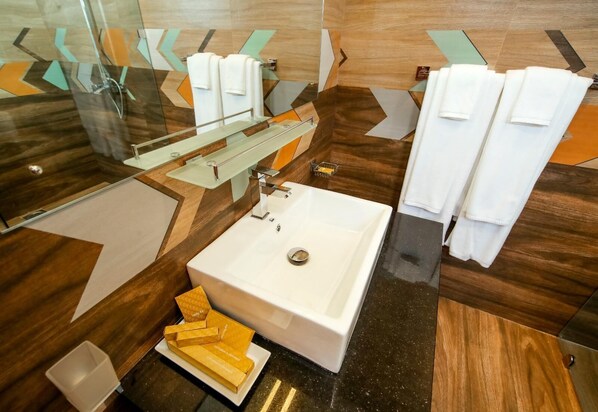 A modern bathroom with a large white sink, a glass shower enclosure, and a mirror. There are multiple white towels and a soap dish on the counter. - Vishwa Retreat Kandy (Kandy)