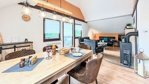 A modern kitchen with a wooden countertop, a built-in stove, and a hanging light fixture. - Cosy apartment in villa for 8 people with WIFI, TV, terrace and pets allowed (Bad Wildungen)