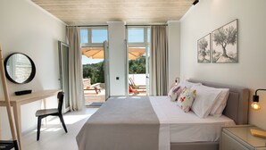 Een slaapkamer met een bed, een bureau, een stoel en een nachtkastje.