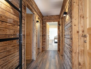 Stylish hallway leads to a bathroom with a bathtub and sink.