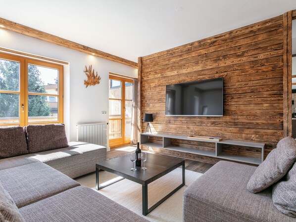 Relax in style with a large flat-screen TV, comfortable seating area, and expansive window views.