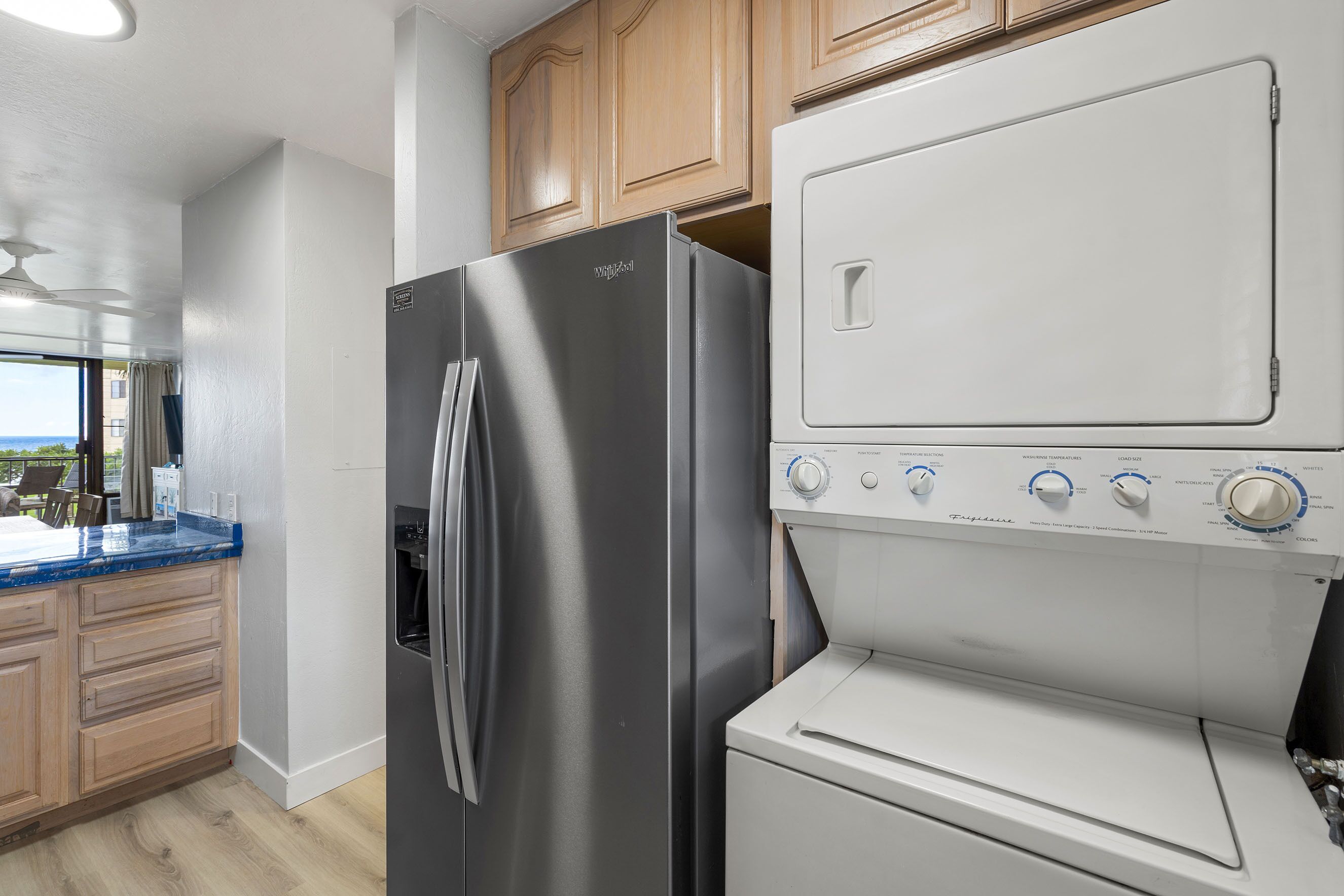 A kitchen with a stainless steel refrigerator, a built-in oven, and wooden cabinets.
