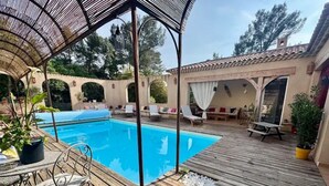 A wooden deck with a pool, lounge chairs, and a pergola. - Gîte 8 pers air-conditioned, 3 bedrooms with bathrooms, private pool. Peaceful (Évenos)