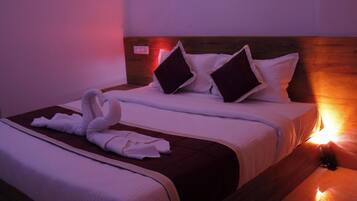 A hotel room with a bed, pillows, and a towel arrangement.