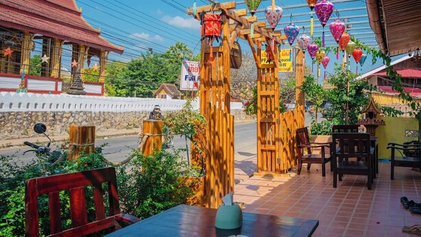 A restaurant with a wooden structure and colorful hanging lanterns.