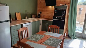 A compact kitchen with wooden cabinets, a built-in oven, and a refrigerator.