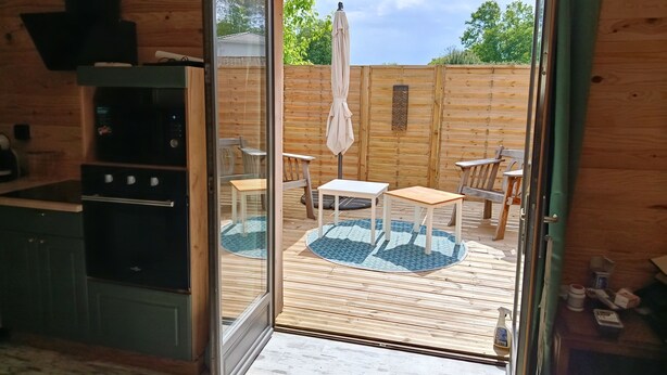 A wooden interior with a sliding glass door leading to an outdoor patio area.