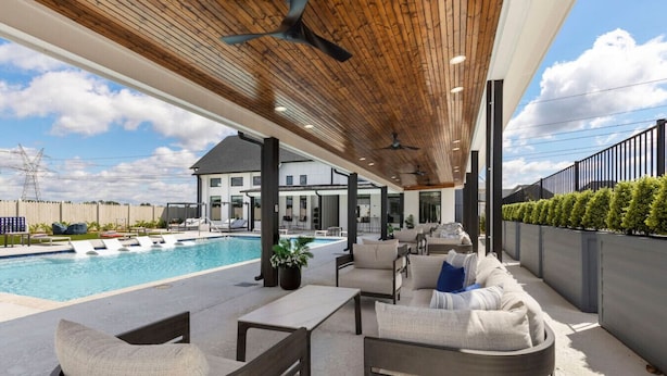 A covered outdoor area with a pool, seating, and a view of a house. - Modern Magnolia Cottage | Pool & Gym Access (Magnolia)