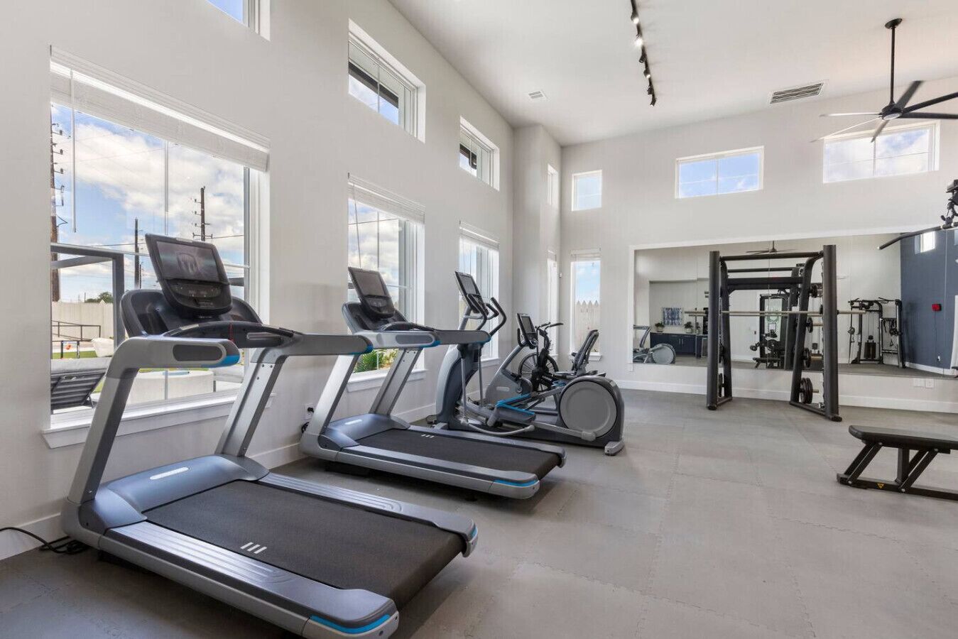 A gym with treadmills, stationary bikes, and weightlifting equipment.