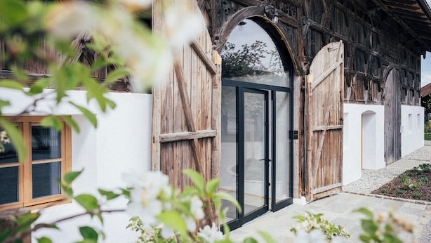 Un bâtiment rustique en bois, doté d’une grande porte vitrée et d’une petite fenêtre.