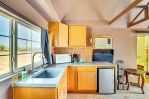 Prepare meals in this kitchen with a large window, microwave, coffee maker, and refrigerator.