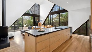 A modern kitchen with a large island, wooden cabinetry, and a view of the outdoors. - Aireys Cliff-Top Gem - Your Ultimate Coastal Escape (Aireys Inlet)