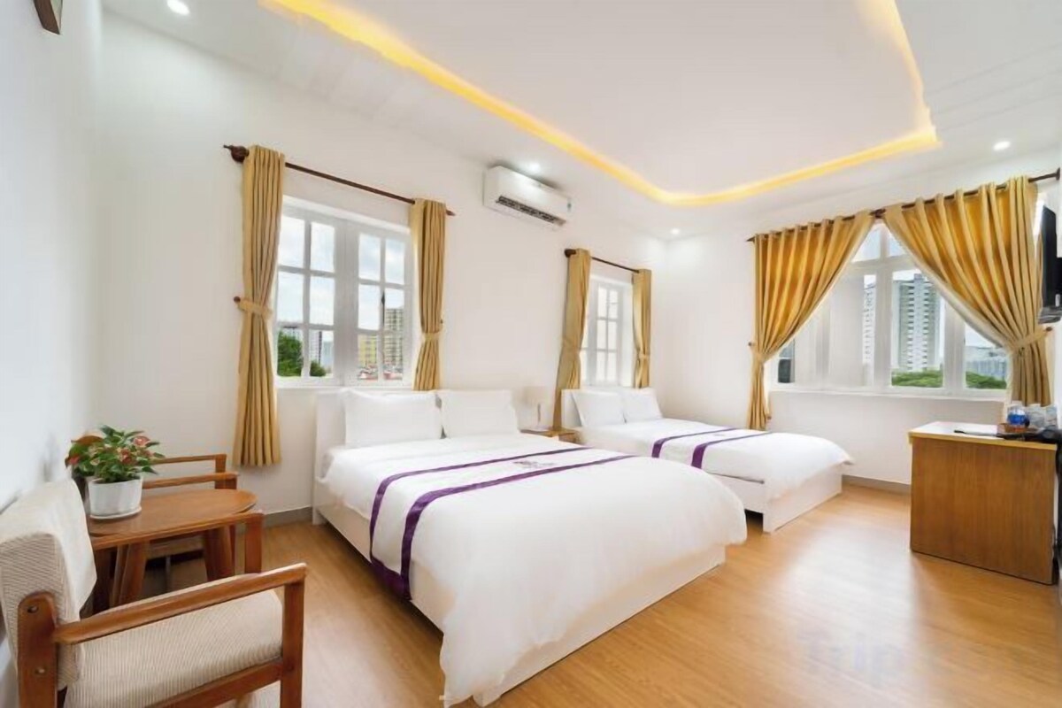 Ein Hotelzimmer mit zwei Betten, einem Schreibtisch, einem Stuhl und einem Fernseher.